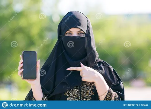 Арабские Обои на телефон человек, одетый в черный головной платок и держащий мобильный телефон
