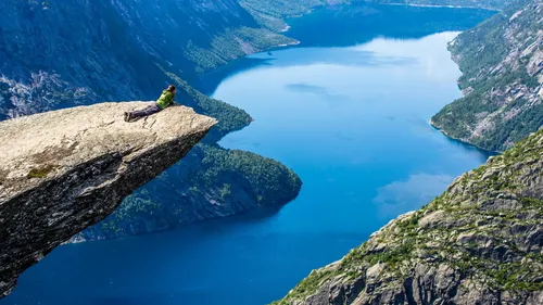 Норвегия Обои на телефон человек, сидящий на скале с видом на водоем