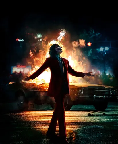 Джокер 4К Обои на телефон человек с высунутыми руками перед автомобилем с огнем за его