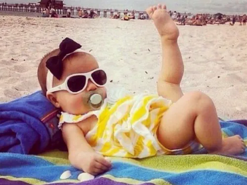 Отпуск Картинки ребенок в солнцезащитных очках и лежащий на полотенце на пляже