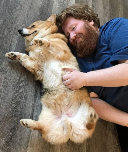 Корги Фото мужчина, лежащий на земле с собакой
