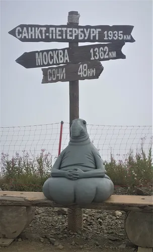 Ждун Фото статуя человека, сидящего под уличным знаком