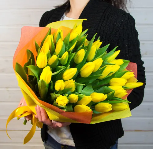 Тюльпаны Фото женщина с букетом желтых цветов