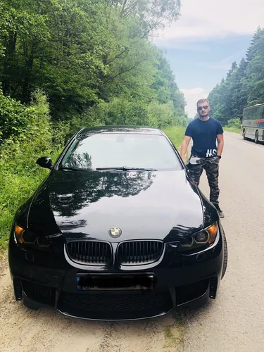 Парня Фото мужчина, стоящий рядом с черной машиной на дороге с деревьями