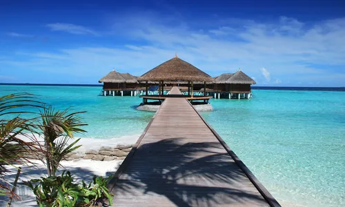 Мальдивы Фото причал, ведущий к небольшой хижине на пляже