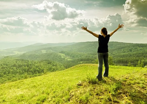 Природа Фото человек, стоящий на холме с поднятыми руками