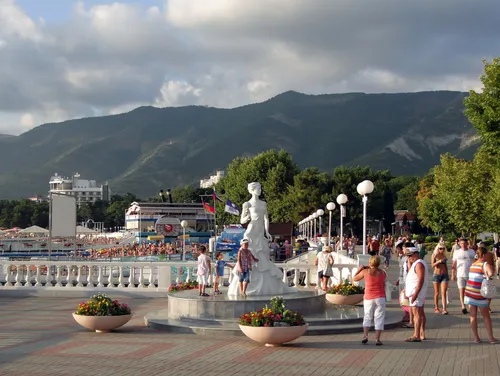 Геленджик Фото группа людей, стоящих вокруг статуи во дворе с горой на заднем плане