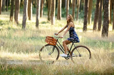 Девушка на велосипеде на фоне заката | Премиум Фото