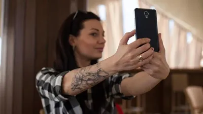Девушка с татуировкой и с оружием в руках - обои на телефон