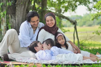 Мусульманская семья сидя на софе с мобильным телефоном Стоковое Фото -  изображение насчитывающей мужчина, изолировано: 82379078