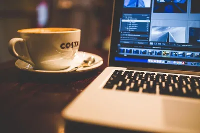 Coffee or tea cup on laptop against the window with sunshine. Cozy  workplace in home office, inspiring view to morning city Stock Photo |  Adobe Stock