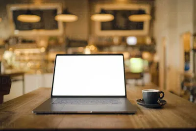 Office table with laptop, coffee cup and a notebook with a pen.Office  objects Stock Photo - Alamy