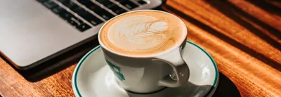 Woman Sitting at a Table with a Cup of Coffee and Working on a Laptop Free  Stock Photo | picjumbo