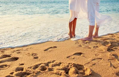 Прекрасная молодая пара на берегу моря прогуливается в час заката. Красивая  девушка и парень влюблены друг в друга. Природа подчеркивает их нежность и  силу. Stock-foto | Adobe Stock