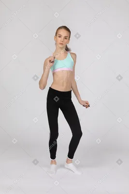 Фото Девушка-подросток в спортивной одежде в полный рост жестикулирует и  танцует