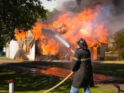 Пожарный в действии тушит пожар в горящем лесу | Премиум Фото