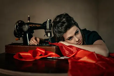 женщина-швея на фоне своей рабочей мастерской занимается пошивом одежды.  меряет кусок ткани Стоковое Изображение - изображение насчитывающей  женщина, машина: 217904895