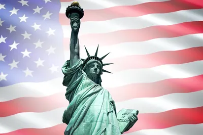 Рука держа игрушку сувенира статуи свободы, реальную статую свободы на  заднем плане Стоковое Фото - изображение насчитывающей символ, национально:  52084744