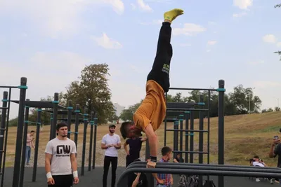 Street workout on a sports ground in Kiev, Ukraine. Bodyweight workout  performed outdoor in city center on bars by young athletic man. Physical  activity, sport concept. фотография Stock | Adobe Stock
