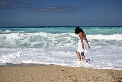 Молодая девушка женщина идет по берегу моря в купальнике выходит из моря  Stock-foto | Adobe Stock