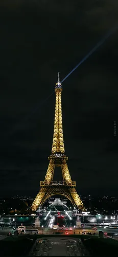 Классические Обои на телефон большая башня, освещенная ночью, на заднем плане Эйфелева башня