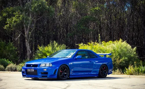 Nissan Skyline R34 Обои на телефон синий спортивный автомобиль, припаркованный на дороге с деревьями и кустами