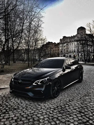 Mercedes Обои на телефон черный спортивный автомобиль, припаркованный на улице с деревьями и зданиями