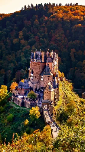 Замок Обои на телефон большой замок, окруженный деревьями, на заднем плане замок Эльц