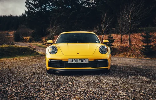 Porsche 911 Обои на телефон желтый автомобиль на грунтовой дороге