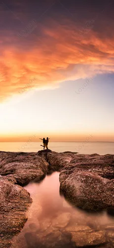 Моие Обои на телефон пара человек, стоящих на скале у воды на закате