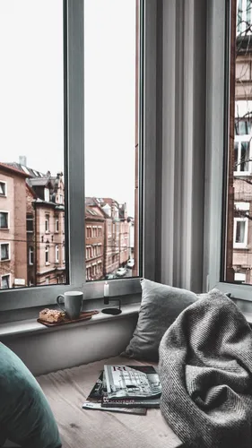 Дом Обои на телефон человек, сидящий на диване, смотрит в окно на город