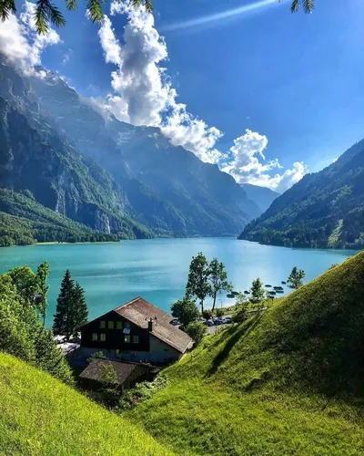 Швейцария Обои на телефон дом на холме у озера с горами на заднем плане