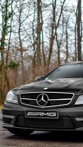 Mercedes C63 Amg Обои на телефон черный автомобиль, припаркованный перед деревьями