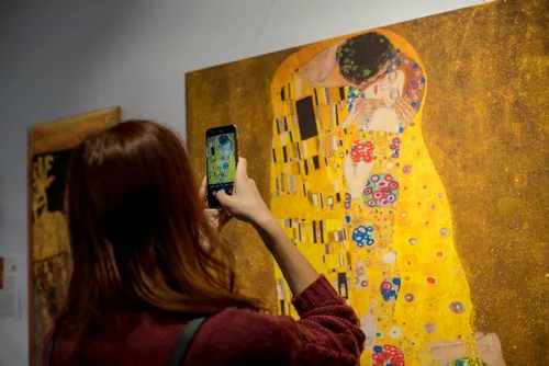 Альфонс Муха, Густав Климт Поцелуй Обои на телефон человек, фотографирующий картину