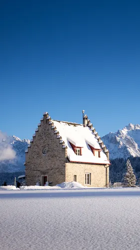 Зима Горы Обои на телефон здание с красной крышей и заснеженной горой на заднем плане