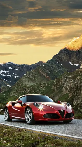 На Телефон Картинки красный спортивный автомобиль, припаркованный на дороге с горами на заднем плане