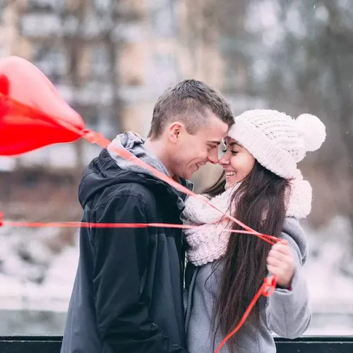 мужчина и женщина держат красный зонт