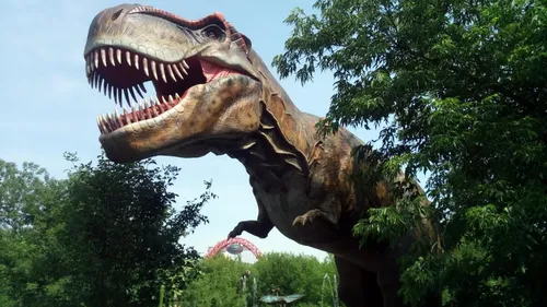 Динозавров Картинки статуя динозавра с деревьями на заднем плане