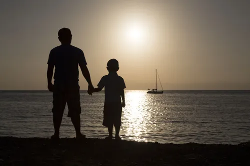 День Сыновей Картинка Картинки мужчина и ребенок стоят на пляже и смотрят на воду