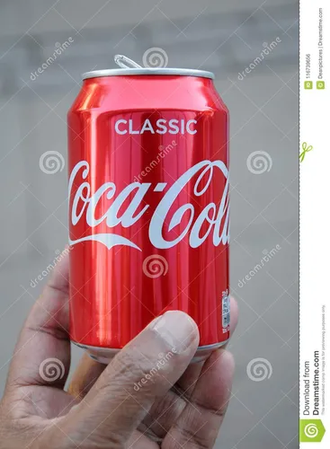 Кока Кола Фото рука, держащая красную банку газировки