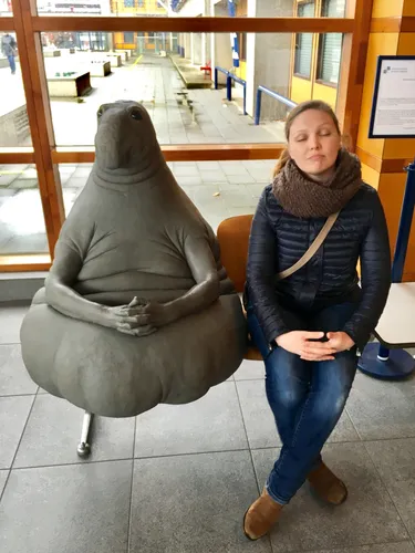 Ждун Фото женщина, сидящая рядом со статуей