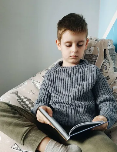 Для Описания Картинки мальчик, сидящий на кровати и читающий книгу