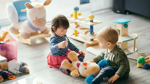 Игрушек Картинки пара детей сидят на полу с мягкими игрушками