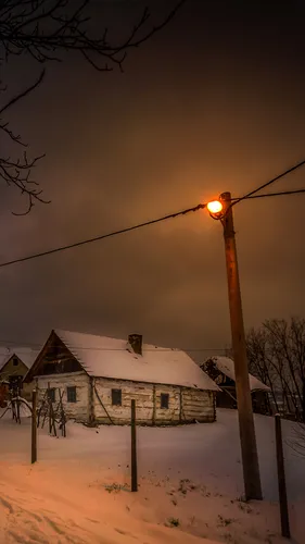 Зимние Обои на телефон заснеженный двор с домом и уличным фонарем