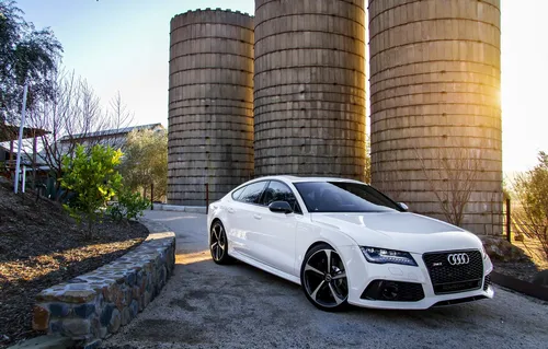 Audi Rs7 Обои на телефон белый автомобиль, припаркованный перед большой стопкой шин