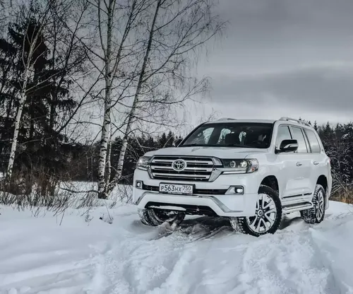 белый автомобиль, припаркованный в снегу