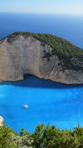 Греция Обои на телефон лодка в воде у скалы