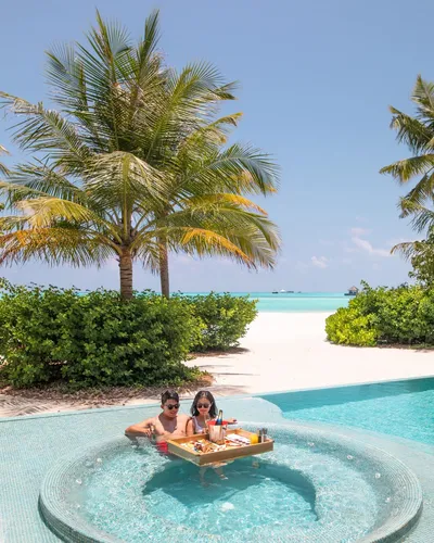 Мальдивы Фото мужчина и женщина в бассейне у пляжа и пальм