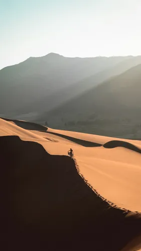 Пустыня Обои на телефон человек, идущий по песчаной дюне