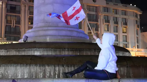 Флаг Грузии Обои на телефон человек, сидящий на фонтане с флагом